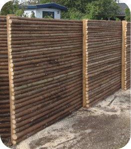 Vandret hegn i haven med trykimprægnerede stolper og rafter med bark Vandret hegn i haven med trykimprægnerede stolper og rafter med bark